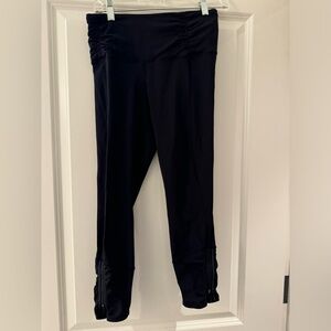 Black midcalf Lululemon legging with zipper and ruching at the bottom.
